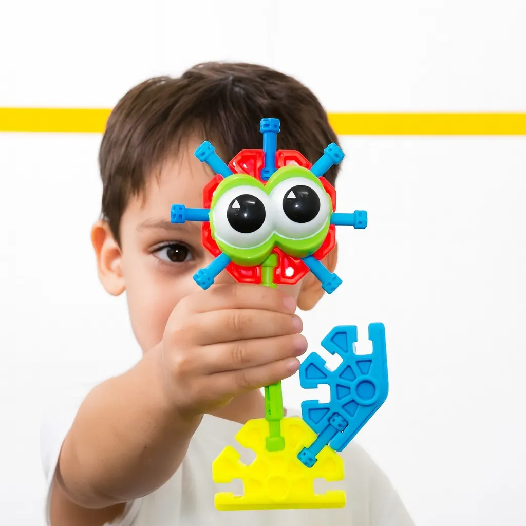 Aluno segurando um personagem montado com peças K'NEX em aula de robótica